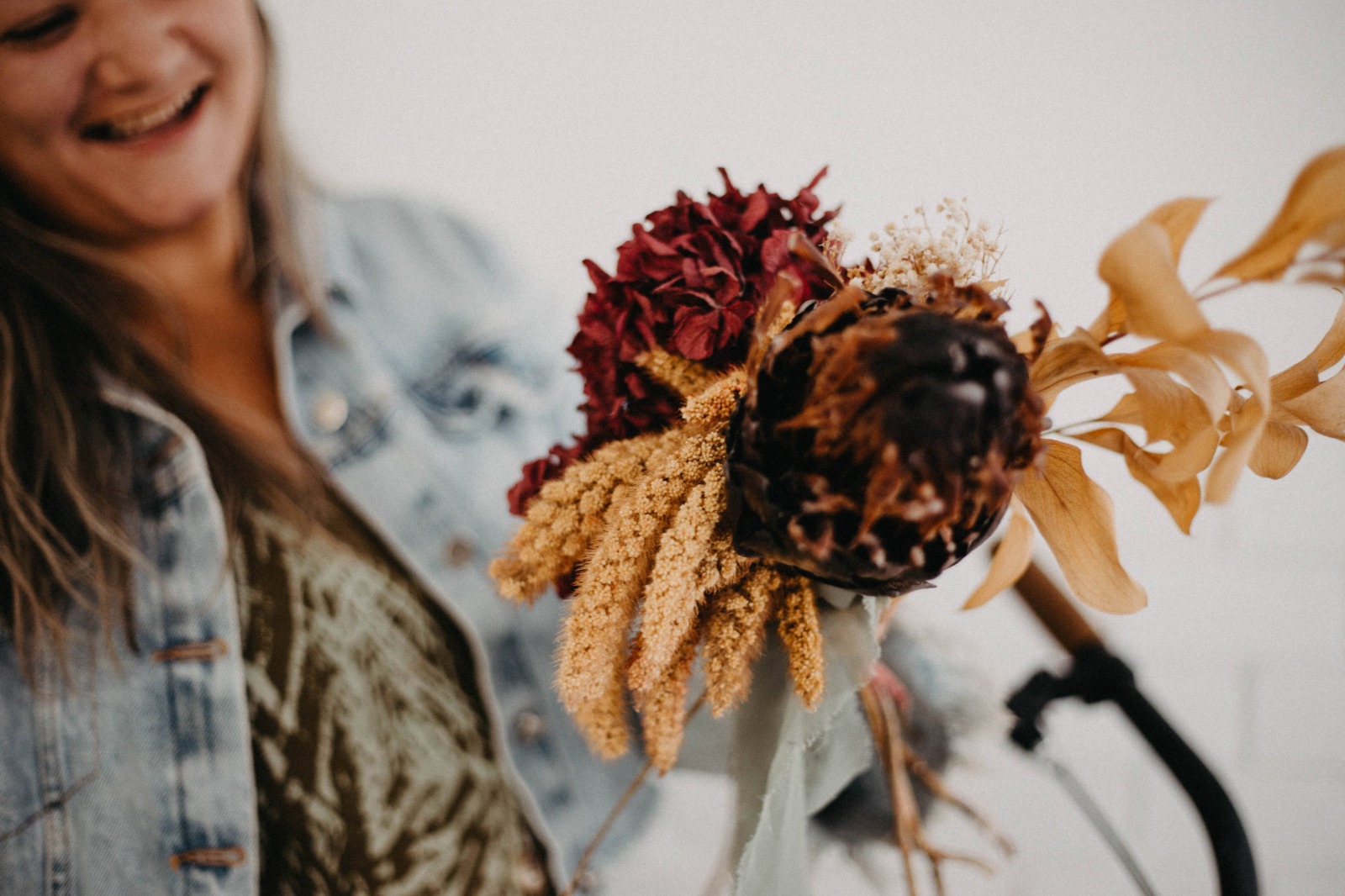 Priscila Velasque com arranjo floral em primeiro plano